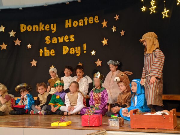 Year 1 NHP children standing on stage in their nativity performance of Donkey Hoatee Saves the Day